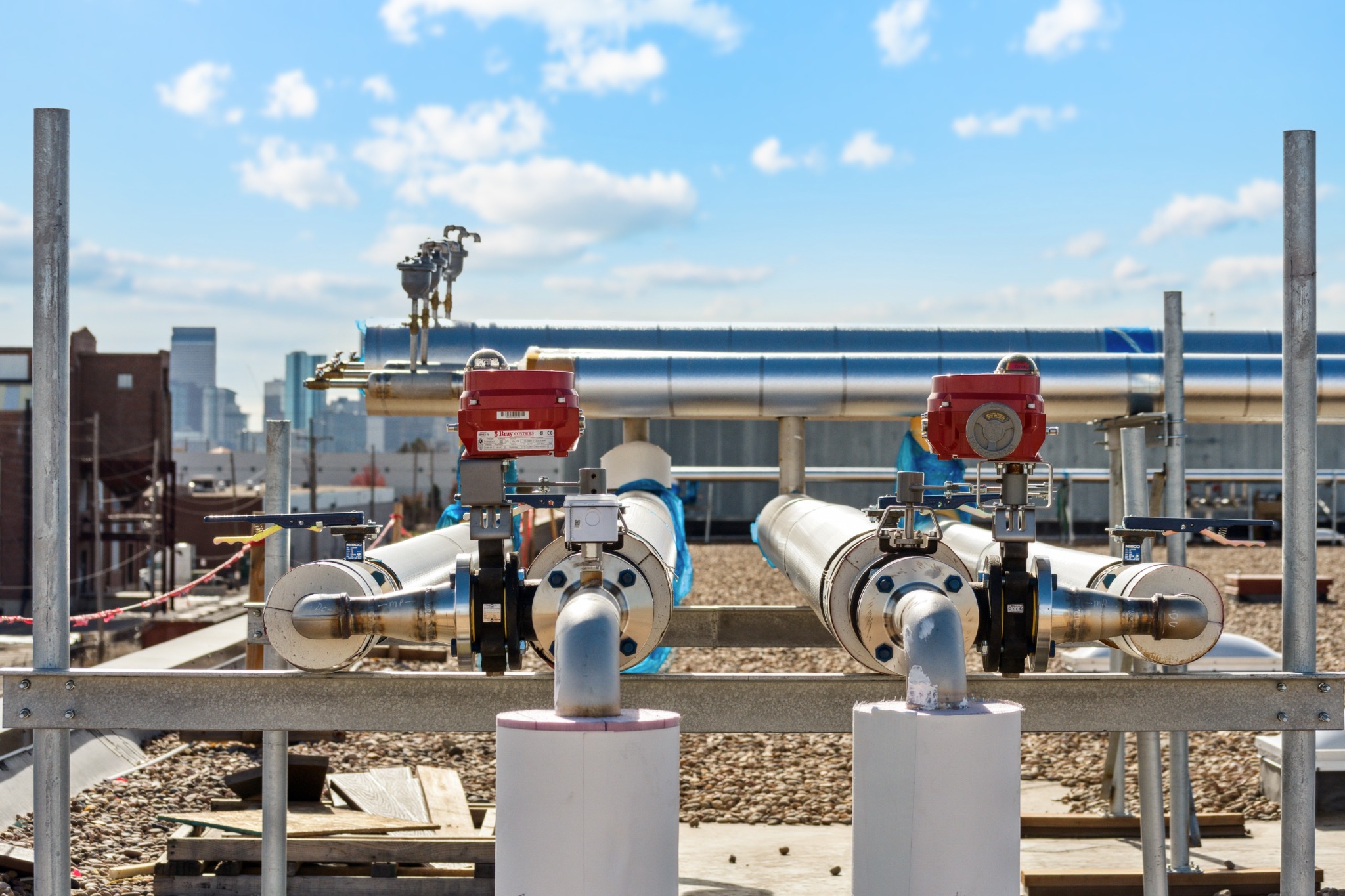 Stainless steel rooftop valve and piping installation with the Denver skyline